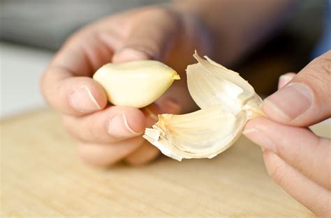 Peel the skins from the garlic. Slice your garlic cloves into thin slices.. 1/8" thickness works well. Line a baking pan with parchment paper and spread your garlic slices out. Set your oven to the lowest temperature it goes, usually between 130-150 degrees, and insert your sliced garlic.